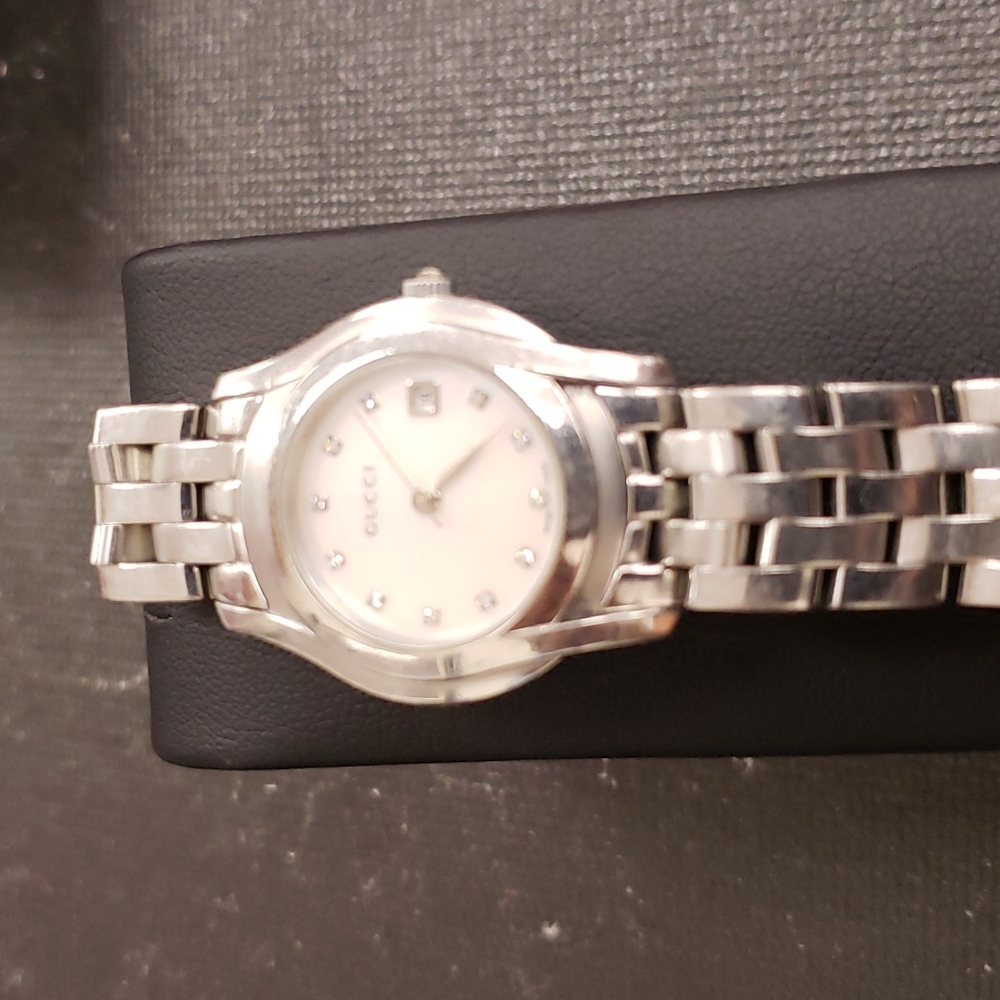 Gucci watch with Mother of Pearl and diamond face.